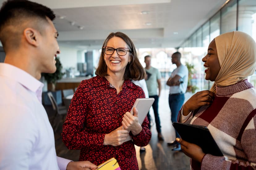 Middle aged women in glasses faces two individuals with a smile