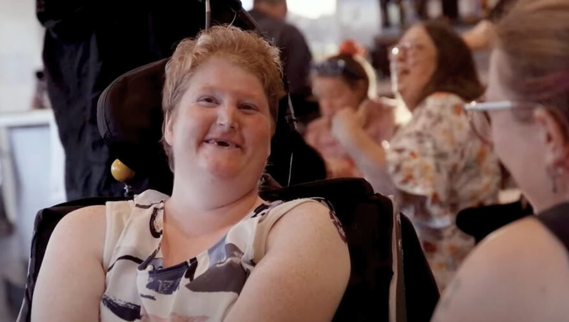 EasyBeatz Disco participant on the dancefloor smiling in their wheel chair