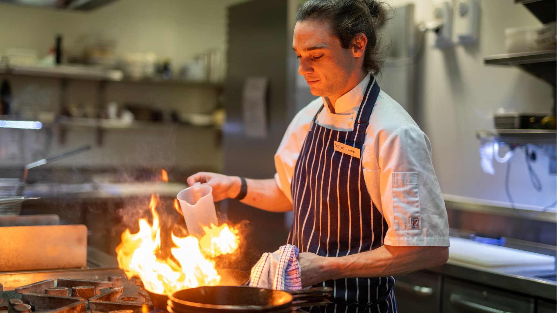 Declan cooking over a flame in the kitchen