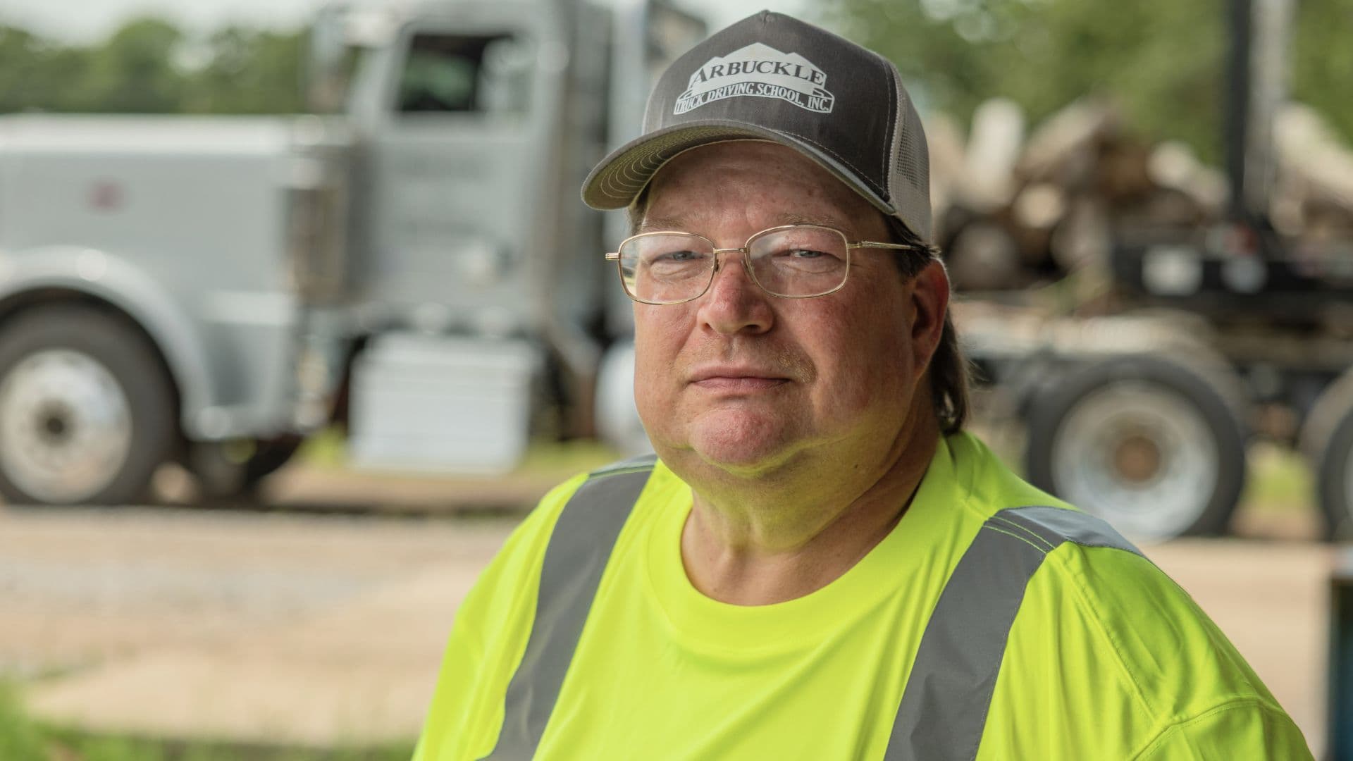 Portrait of Ocie with a neutral expression and his truck in the background