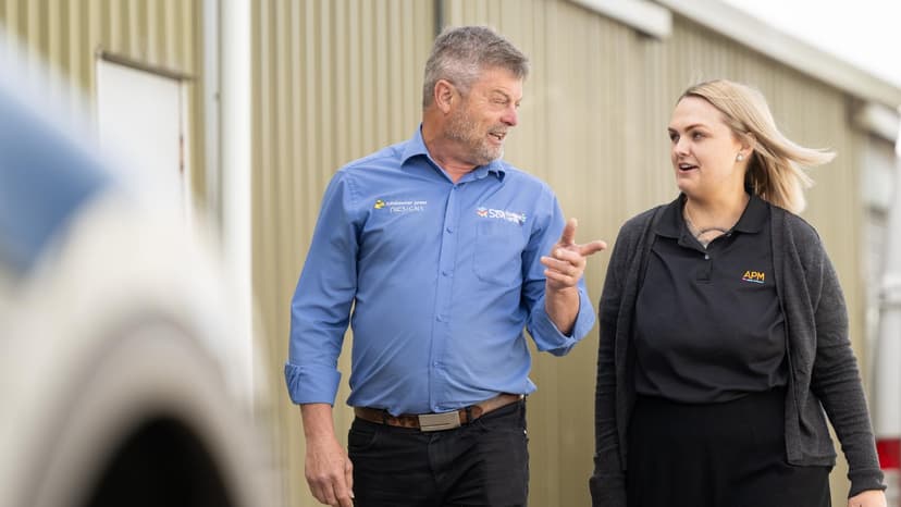 An employer in a blue shirt talks to an APM consultant