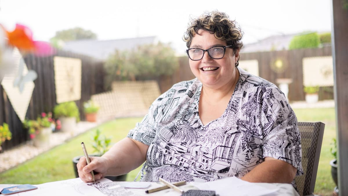 Natalie sat at a table at home doing art in her backyard