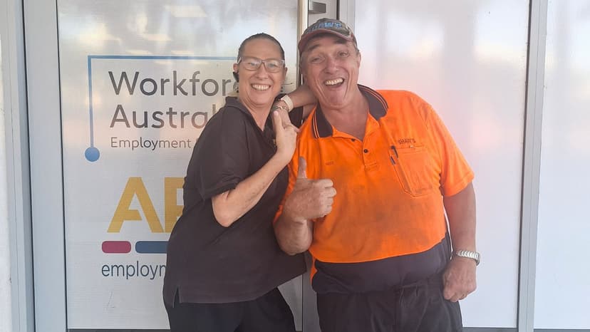A man smiles and gives a thumbs up with a woman outside APM
