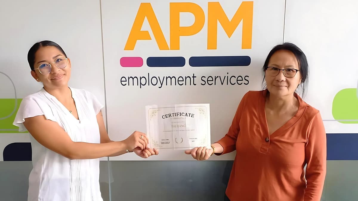 DES participant Thi holds a certificate outside her APM branch with consultant Almaree