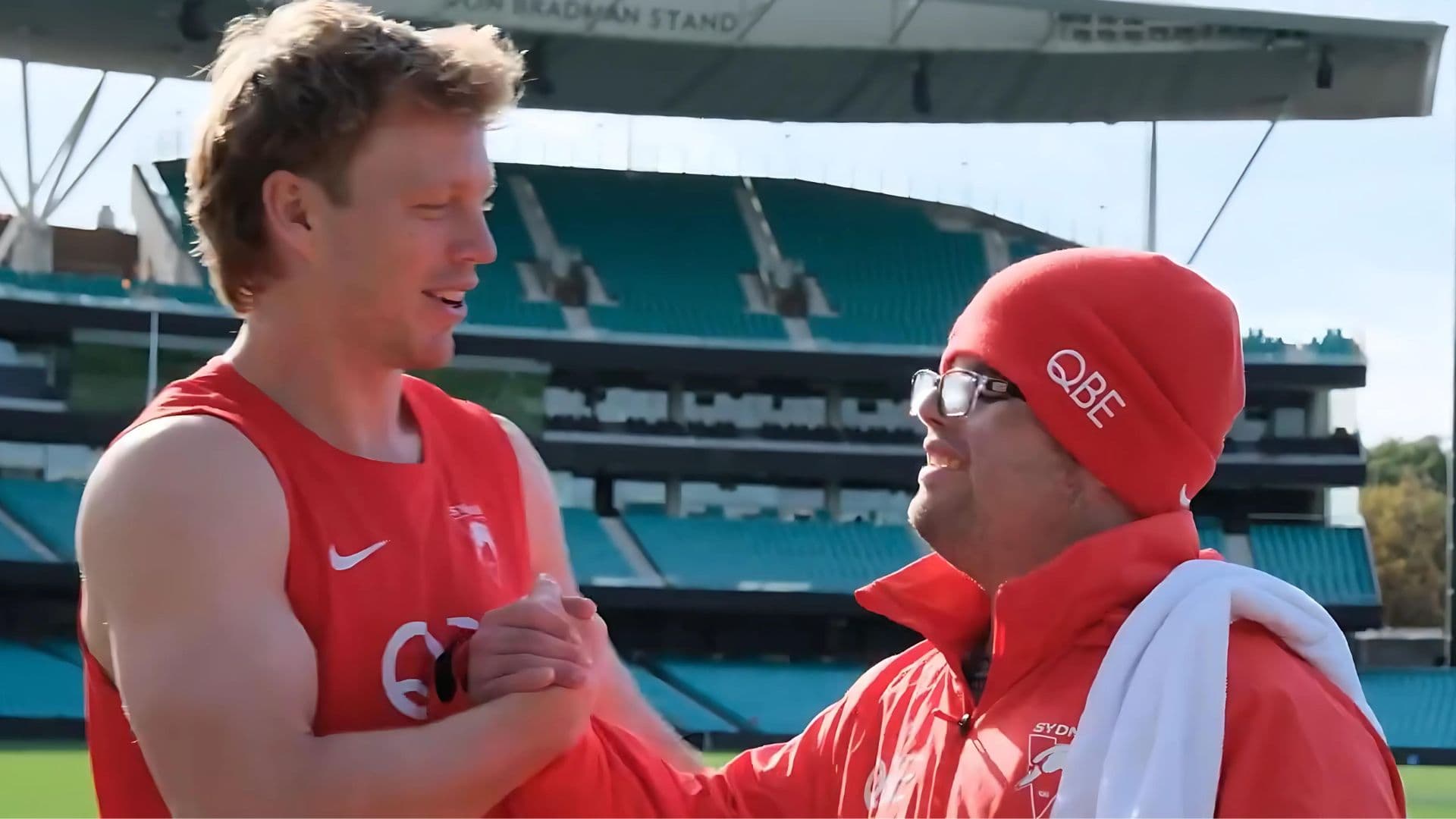Adam shakes hands with a Sydney Swans player during training