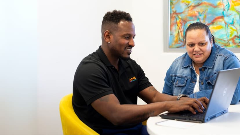 An APM consultant speaks to a job seeker in an APM branch