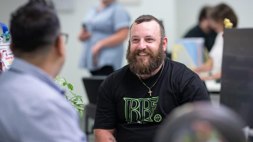 A Workforce Australia participant smiles in conversation with an APM team member