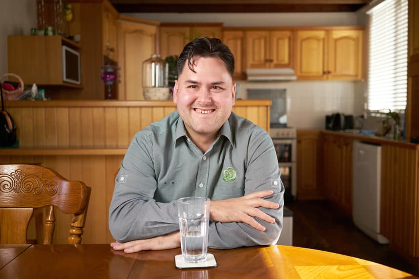 Participant Caley smiles sitting indoors at a dining table