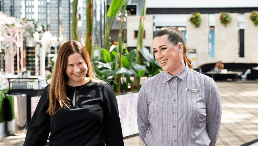 Participant Ashley smiles with her employer inside a hotel foyer