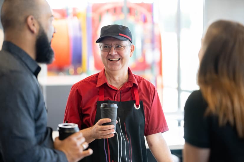 Participant Darren smiles as he talks to people at work