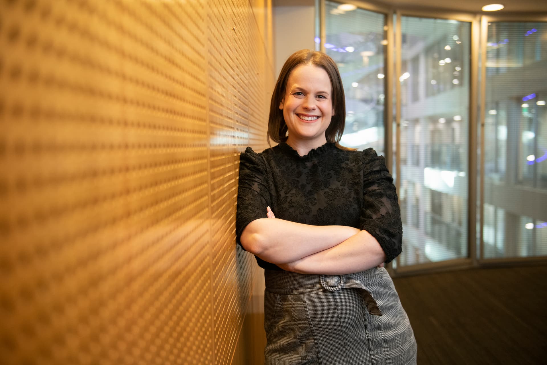 Female empowered employee facing camera with arms crossed