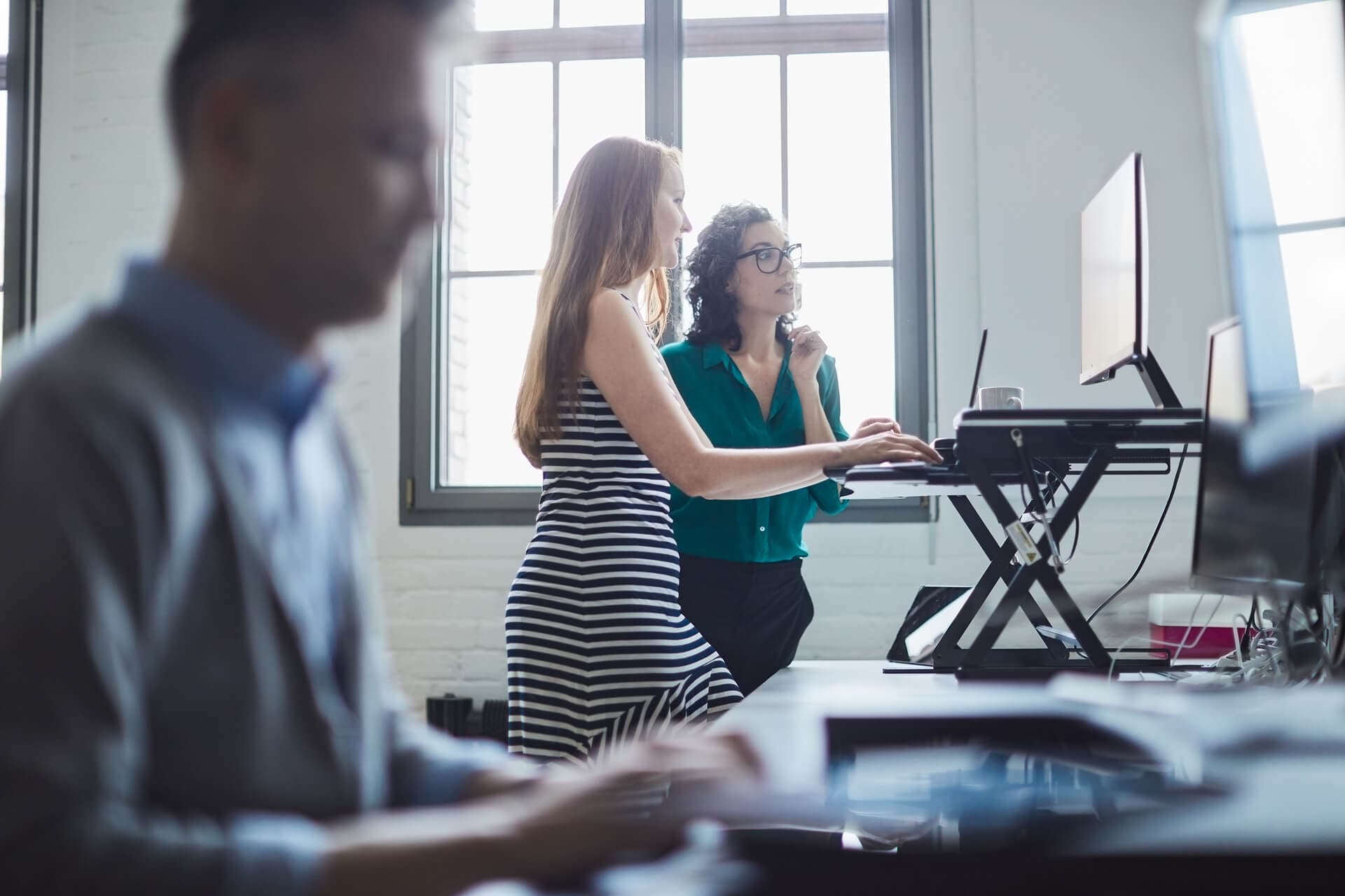 Two employees working at a standing desk