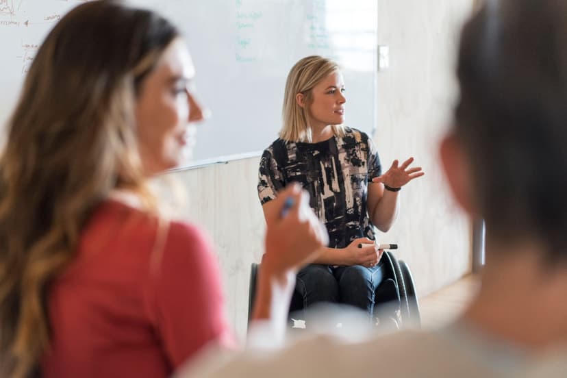 Female in wheelchair, facilitating a team meeting
