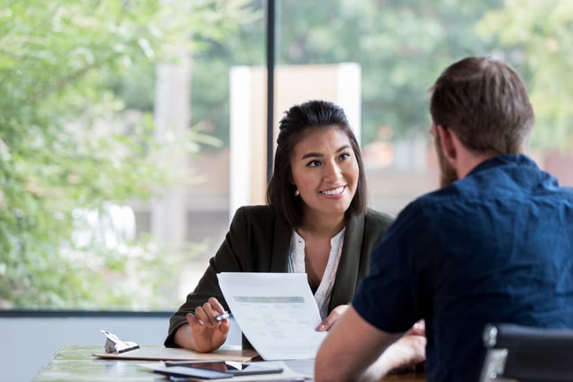 Female consultant with papers in hand, speaking with a male