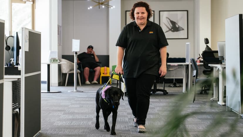 APM Communities Alyesha walking her assistance dog through the office
