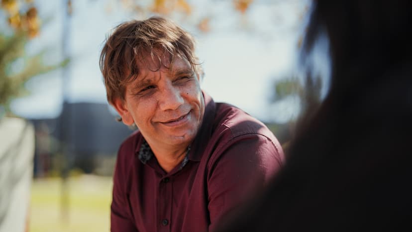Jamie smiling with APM Communities team member sitting outside on park bench.