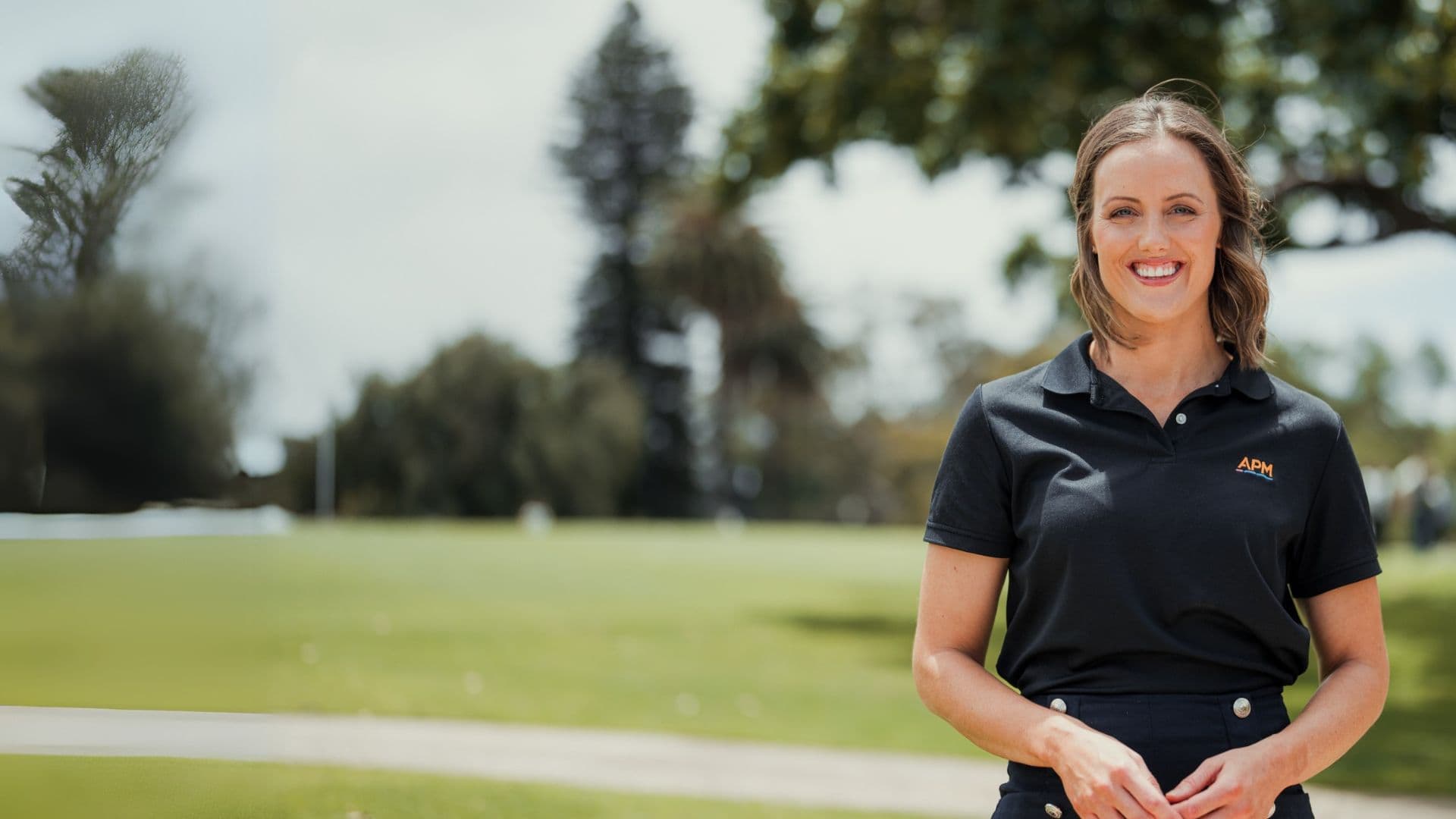 Ellie Cole in a park wearing an APM polo