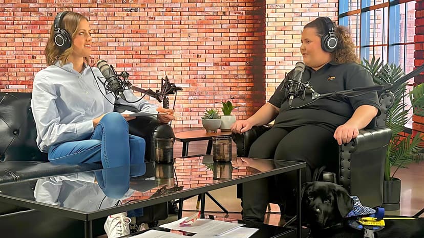 Two people sitting opposite eachother with headphones and podcast recording gear