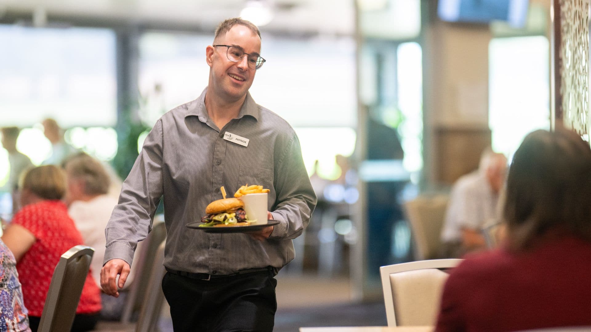 Pat serves bistro customers where he has worked for 10 years since getting supprt from APM.