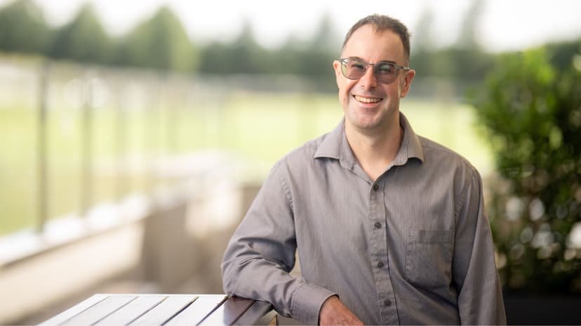 Pat smiles outside a country club in his work uniform