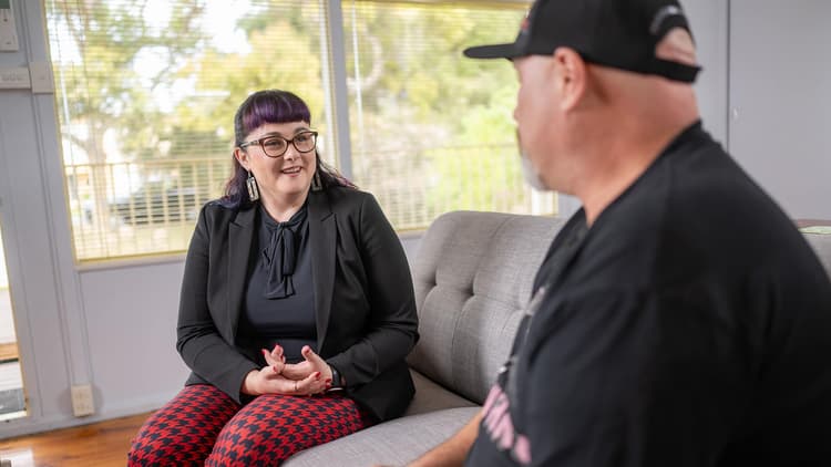 Inclusive Employment Australia consultant sitting on a sofa listening to a job seeker