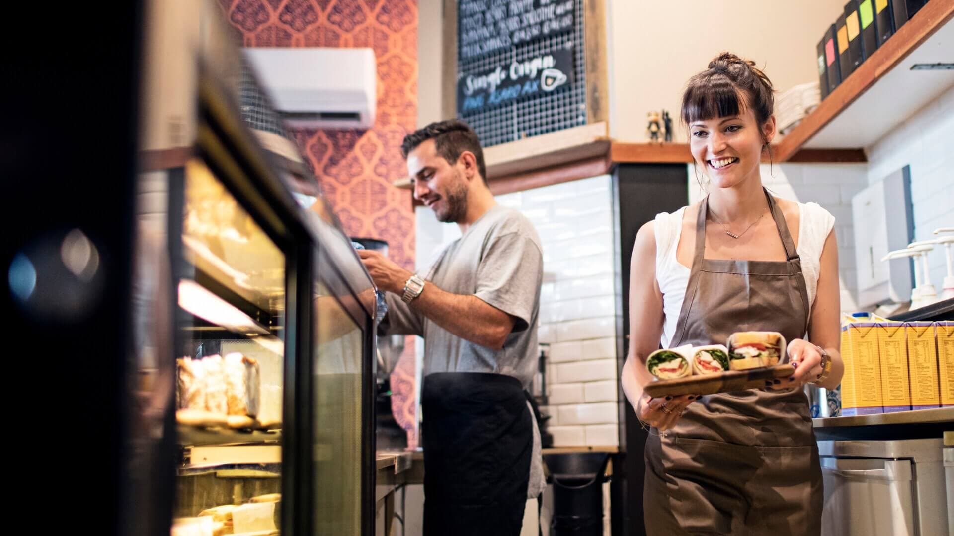 Two café workers working behind the counter