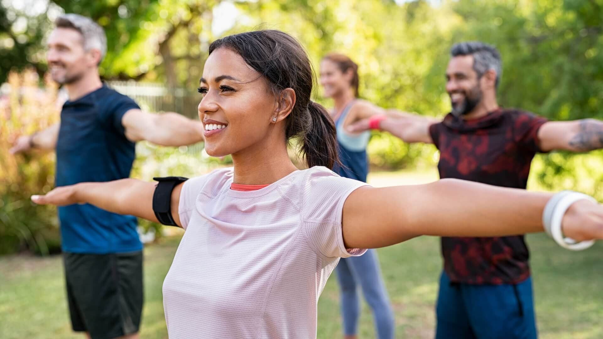 A group of people stretching in an outdoor exercise class