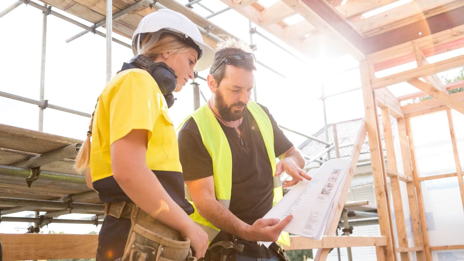 Two construction site workers discussing a plan