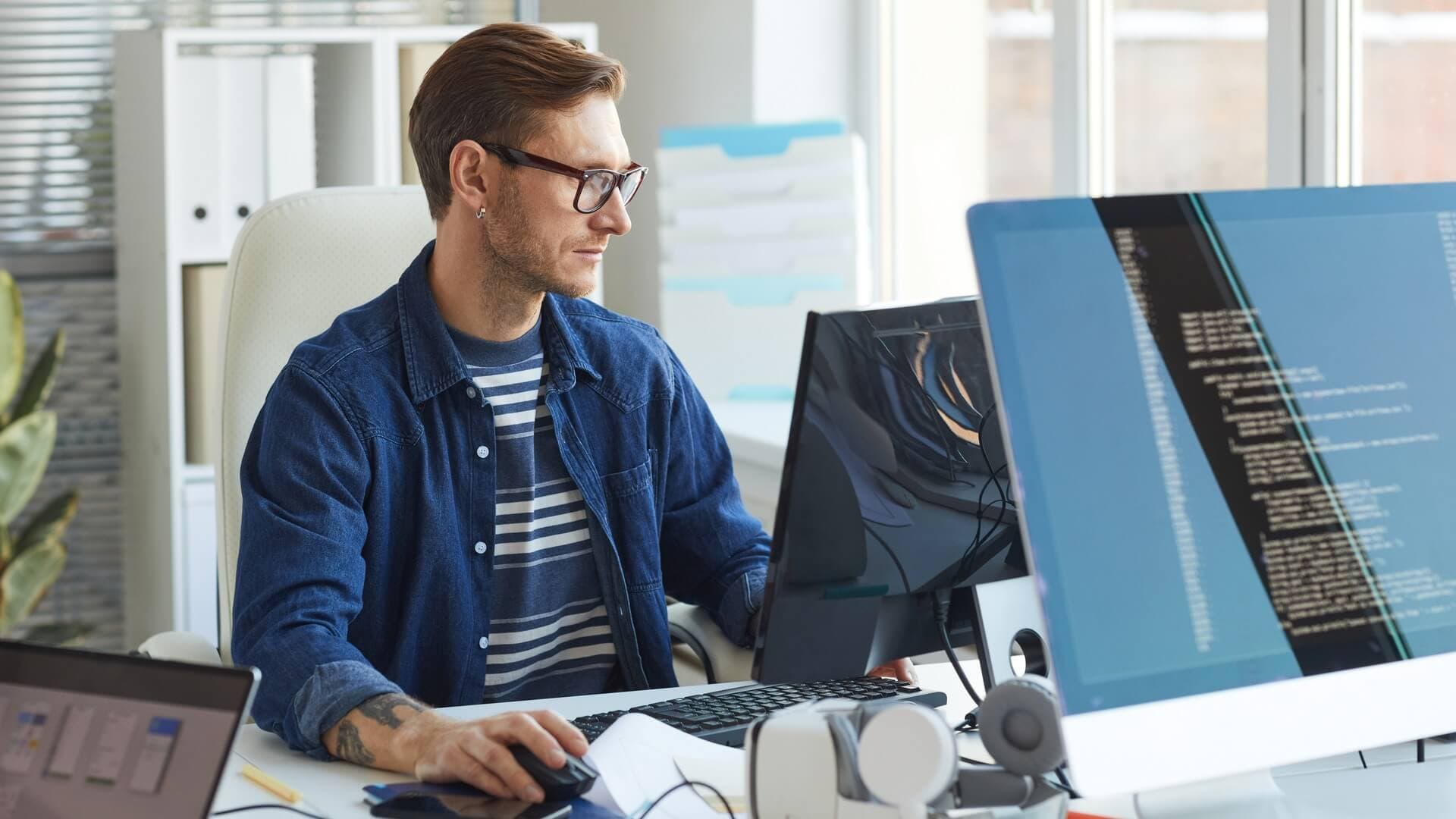 A man working on a computer in an open plan office