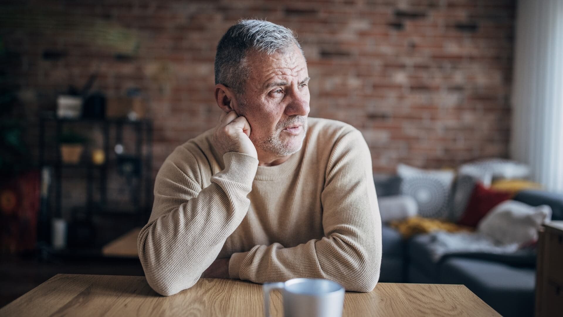 A man sitting contemplatively while having a coffee