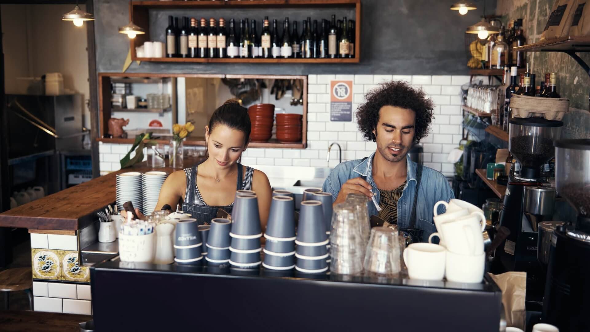 Two baristas making coffee in a café