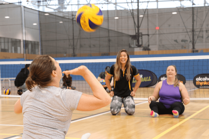 Players sitting on a court about to hit a volleyball