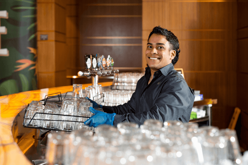 Clyde smiles at work preparing to clean a tray of glassware