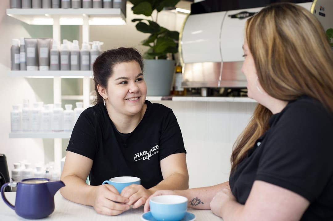 Participant Jess and an APM consultant drinking coffee at a table