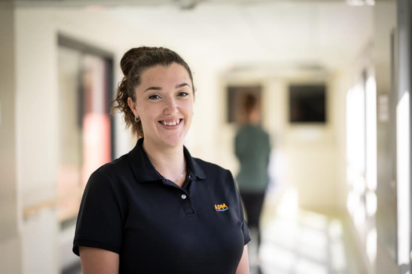 APM EC Emily in a black APM polo