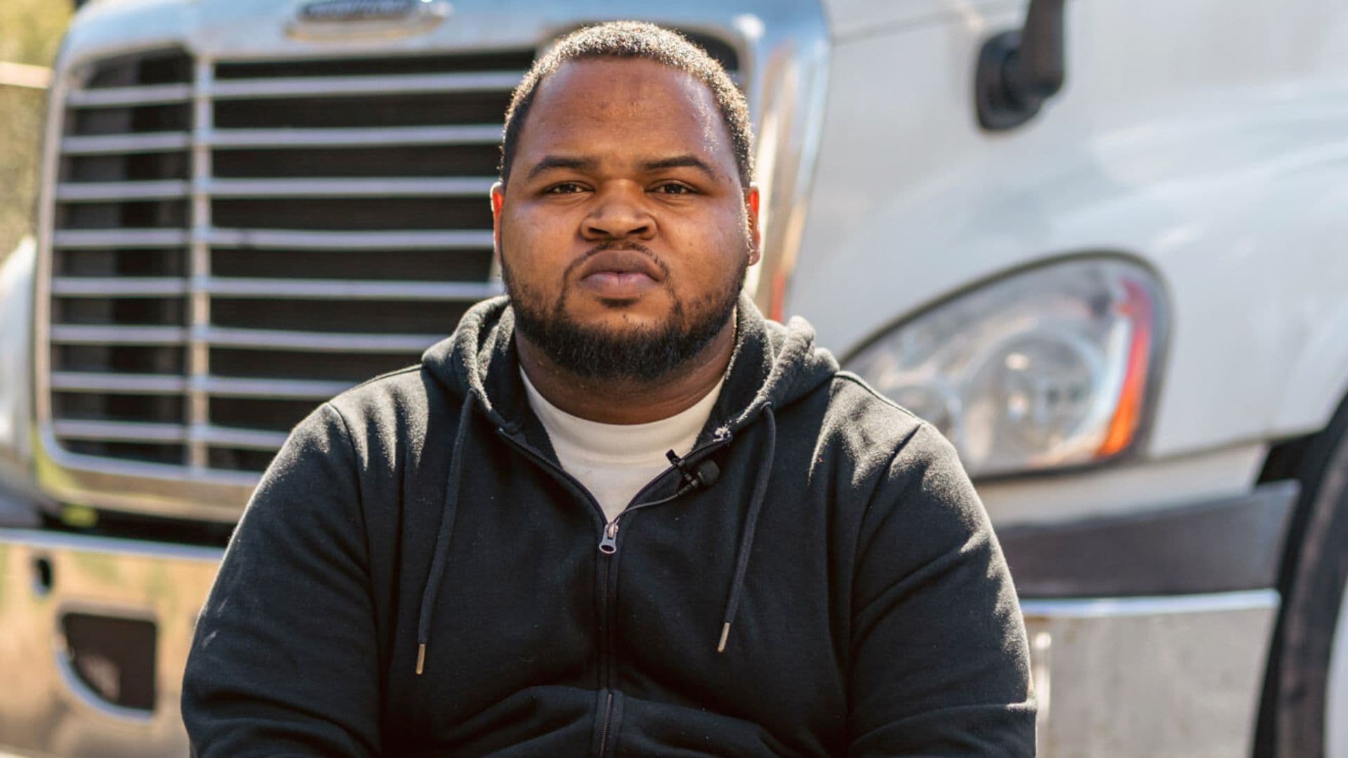 Kion from the Rossworks Career Advantage Program seated outdoors in front of a white commercial truck.